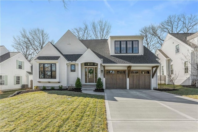 view of front of home with driveway, an attached garage, a front lawn, and roof with shingles