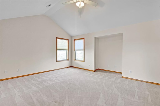 carpeted spare room featuring baseboards, a ceiling fan, and vaulted ceiling