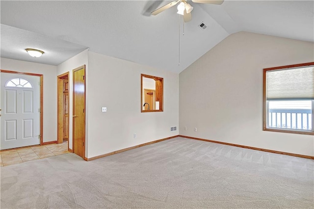 foyer entrance featuring vaulted ceiling, baseboards, visible vents, and light carpet