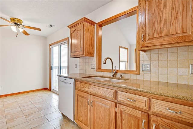 kitchen with light tile patterned floors, light stone countertops, visible vents, a sink, and dishwasher