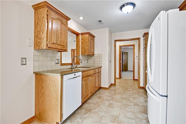 kitchen with white appliances, visible vents, a sink, decorative backsplash, and light countertops