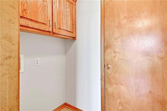 laundry room featuring baseboards and cabinet space