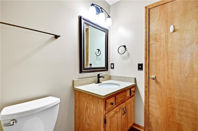 half bathroom with vanity and toilet