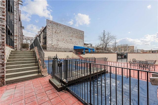 view of patio / terrace featuring stairs and fence