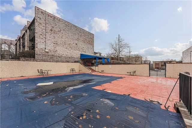 view of swimming pool with a gate, a patio, and fence