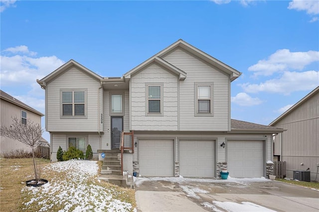 split foyer home with an attached garage, stone siding, and central AC unit