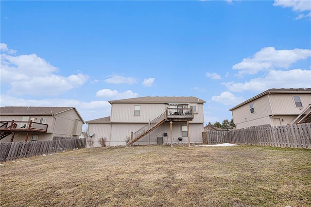 back of property with central air condition unit, a fenced backyard, stairs, and a yard