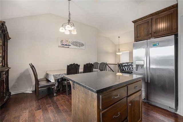 kitchen featuring dark brown cabinetry, dark wood-style flooring, a kitchen island, vaulted ceiling, and stainless steel fridge