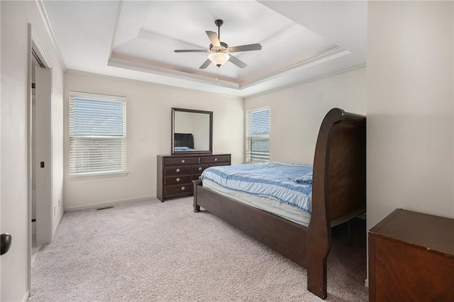 bedroom featuring carpet, baseboards, a raised ceiling, and a ceiling fan