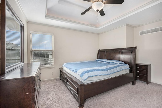 bedroom with light carpet, visible vents, a raised ceiling, ceiling fan, and crown molding