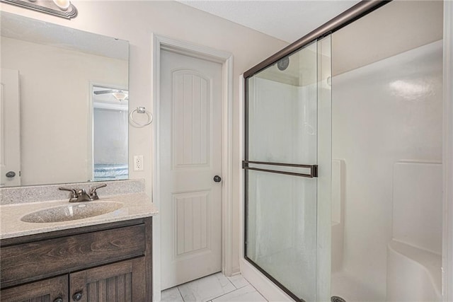 full bath featuring marble finish floor, a shower stall, and vanity