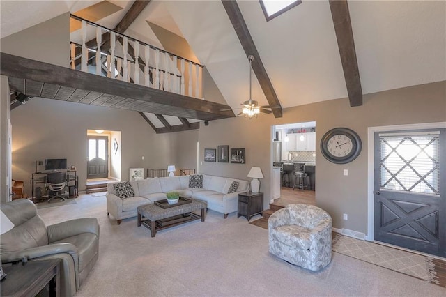 carpeted living area with high vaulted ceiling, beamed ceiling, baseboards, and a ceiling fan