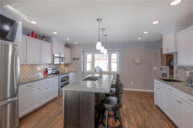 kitchen featuring appliances with stainless steel finishes, white cabinetry, a sink, and dark wood-style floors