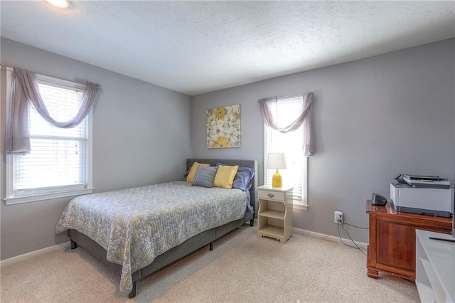 carpeted bedroom featuring baseboards and a textured ceiling