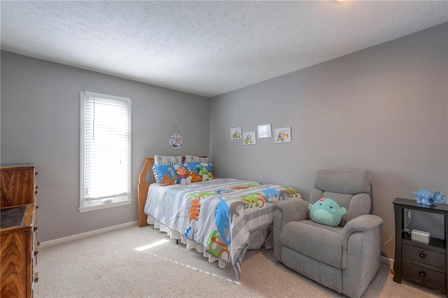 carpeted bedroom featuring a textured ceiling and baseboards