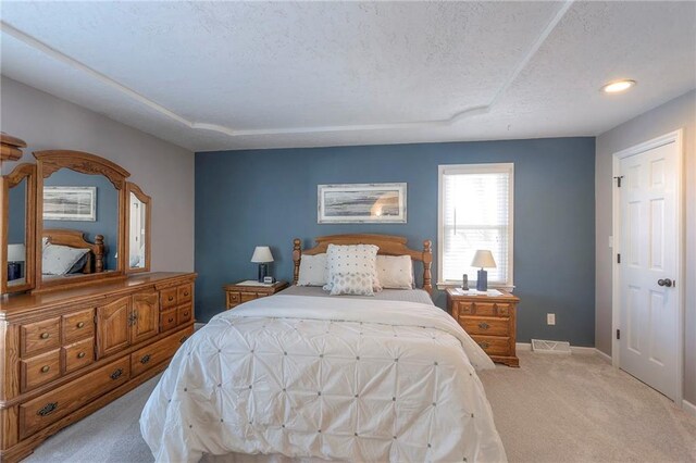 bedroom with visible vents, a textured ceiling, baseboards, and carpet flooring