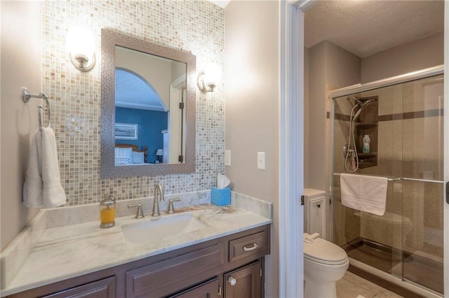 bathroom with a stall shower, vanity, toilet, and a textured ceiling