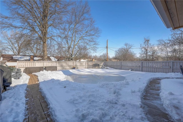 snowy yard featuring a fenced backyard