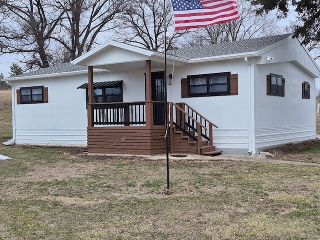 view of front of property featuring a front yard and roof with shingles