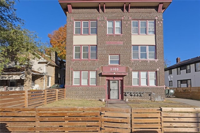 view of front of property featuring brick siding and a fenced front yard