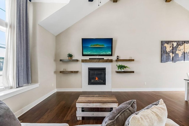 living area featuring a tiled fireplace, baseboards, and wood finished floors