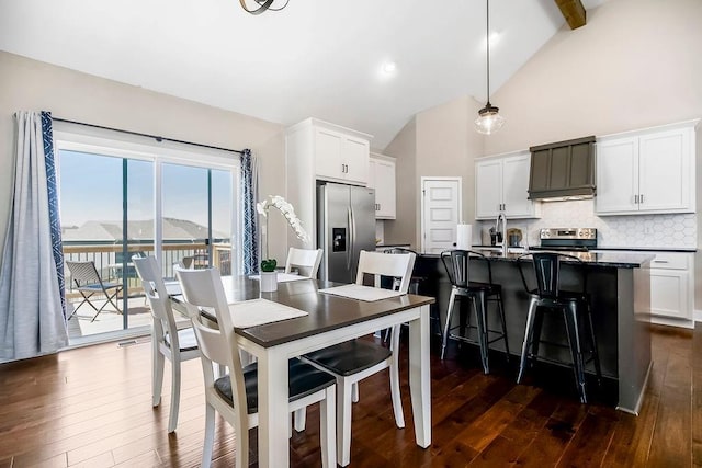 dining area featuring beamed ceiling, high vaulted ceiling, and dark wood-type flooring