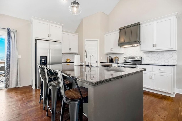 kitchen featuring premium range hood, a sink, dark wood-style floors, stainless steel appliances, and vaulted ceiling