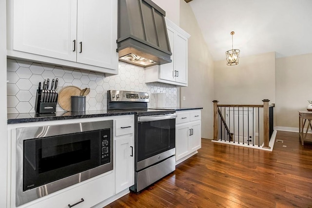 kitchen with stainless steel range with electric stovetop, dark wood finished floors, built in microwave, lofted ceiling, and custom exhaust hood