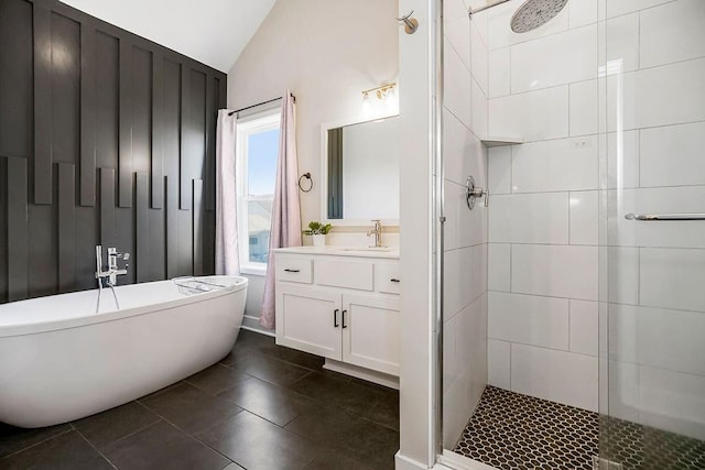 bathroom with tile patterned floors, a shower stall, lofted ceiling, a freestanding bath, and vanity