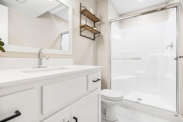 full bath with vanity, a shower stall, toilet, and marble finish floor