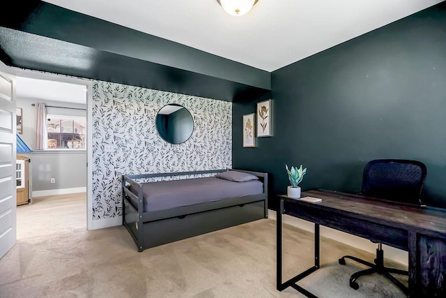 carpeted bedroom with wallpapered walls, an accent wall, and baseboards