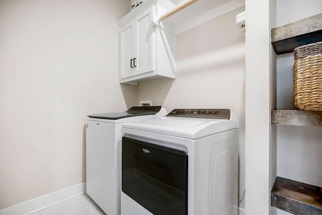 laundry area featuring cabinet space, washing machine and dryer, and baseboards