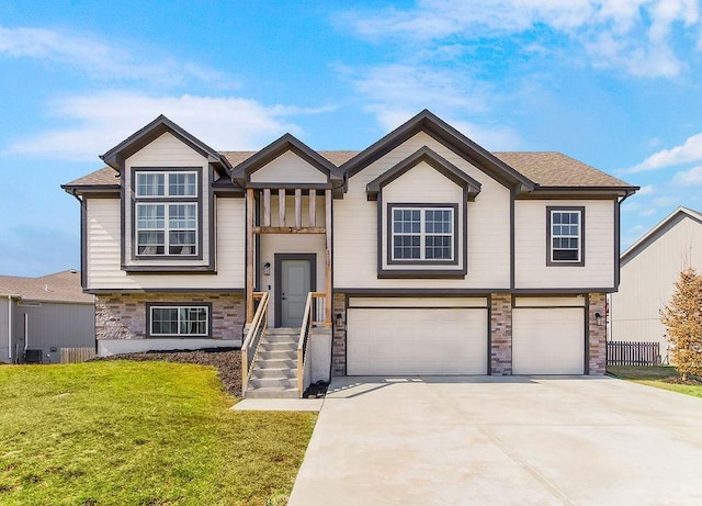 split foyer home featuring driveway, a front yard, and a garage