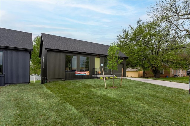 4413 E 135th St, Grandview, MO 64030 - view of front facade with driveway, an attached garage, roof with shingles, and a front yard