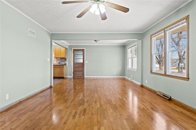 unfurnished living room featuring visible vents, crown molding, and light wood-style floors