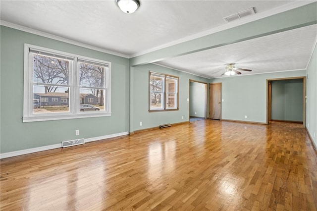 unfurnished room featuring hardwood / wood-style floors, baseboards, visible vents, and ornamental molding