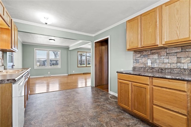 kitchen featuring crown molding, baseboards, tasteful backsplash, and a sink