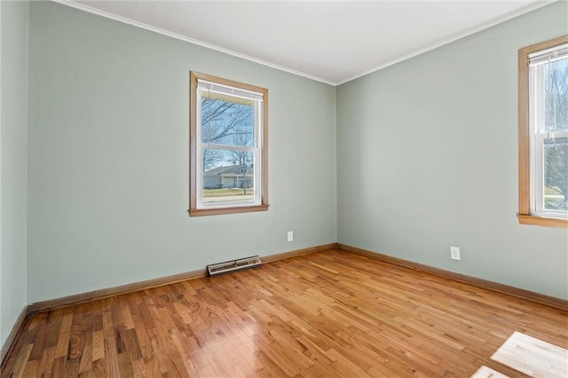 unfurnished room with visible vents, baseboards, crown molding, and light wood finished floors