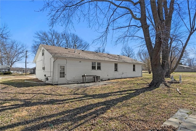 rear view of property featuring a yard and central AC unit