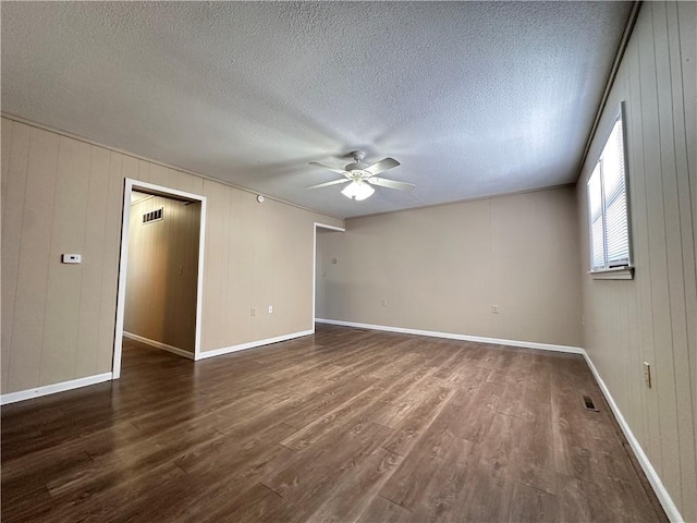 spare room featuring baseboards, visible vents, ceiling fan, dark wood-type flooring, and a textured ceiling