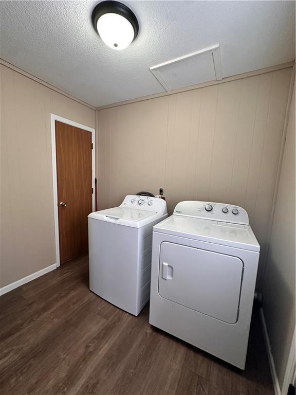 laundry room with a textured ceiling, laundry area, dark wood finished floors, and washer and dryer