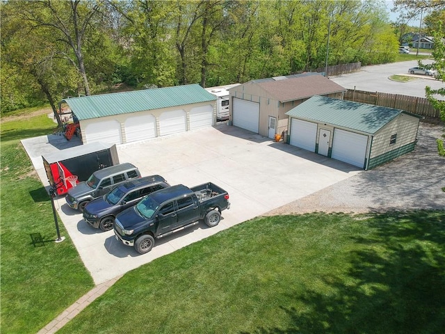 view of front of property featuring a garage, an outbuilding, concrete driveway, and a front yard