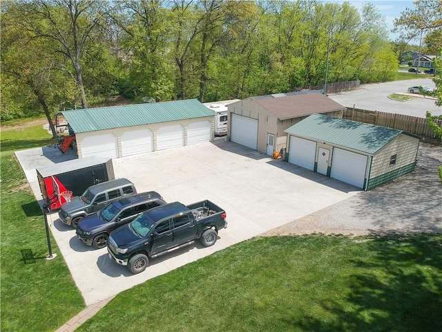 view of front of house with a garage, an outbuilding, driveway, and a front lawn