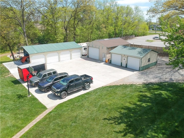 exterior space featuring an outbuilding, driveway, a front lawn, and metal roof