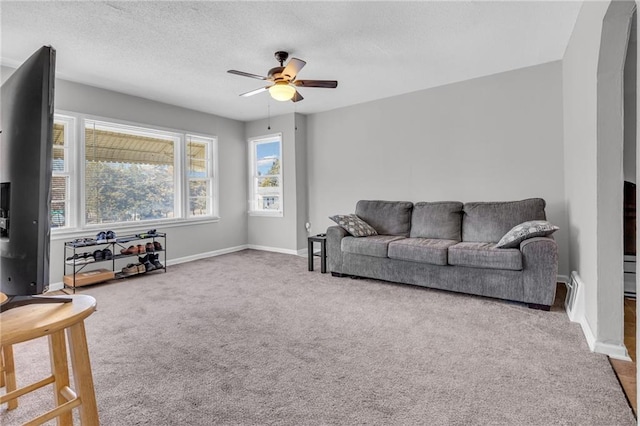 living area with baseboards, a textured ceiling, ceiling fan, and carpet floors