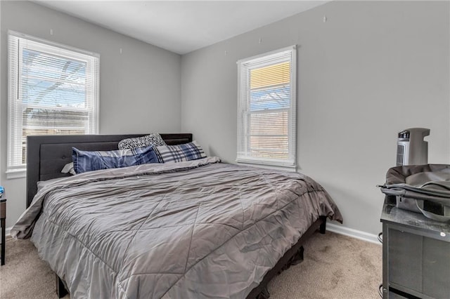 carpeted bedroom featuring multiple windows and baseboards