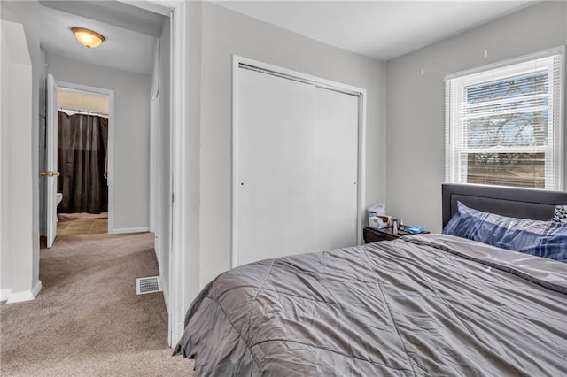 carpeted bedroom featuring visible vents, baseboards, and a closet