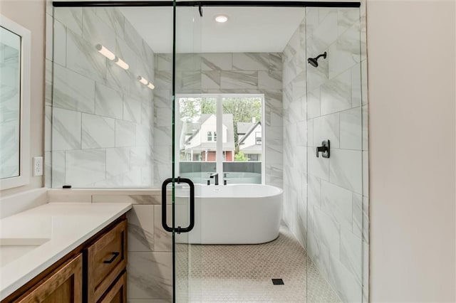 3322 Tracy Ave, Kansas City, MO 64109 - full bath featuring a stall shower, tile walls, vanity, tile patterned flooring, and a soaking tub
