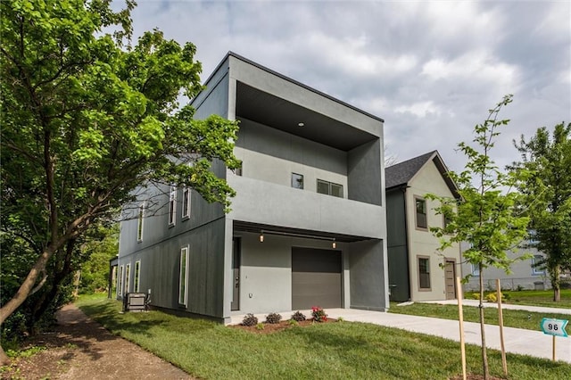 3322 Tracy Ave, Kansas City, MO 64109 - view of front of property featuring a garage, concrete driveway, a balcony, and a front lawn