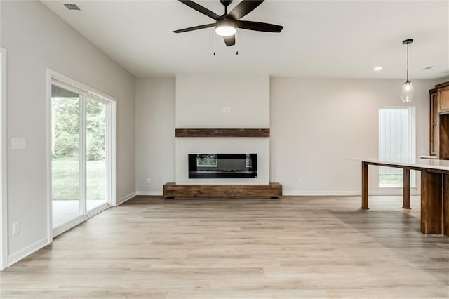 3322 Tracy Ave, Kansas City, MO 64109 - unfurnished living room featuring a glass covered fireplace, light wood-style floors, ceiling fan, baseboards, and recessed lighting